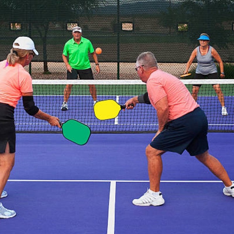 Exciting pickleball doubles match on a vibrant purple court Four players engaged in a doubles pickleball match on a purple court