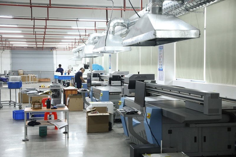 High-tech pickleball paddle manufacturing and printing workshop Modern pickleball paddle production facility with workers operating printing and assembly equipment.