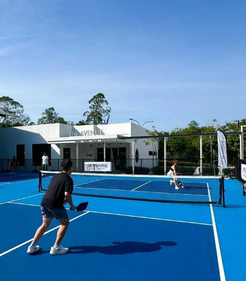 Outdoor pickleball match on a blue court with a scenic background Two players competing on a vibrant blue pickleball court under a clear sky