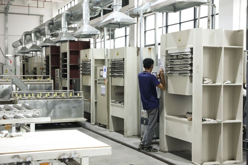 Pickleball paddle production process in a modern factory A worker operating machinery in a pickleball paddle manufacturing facility.