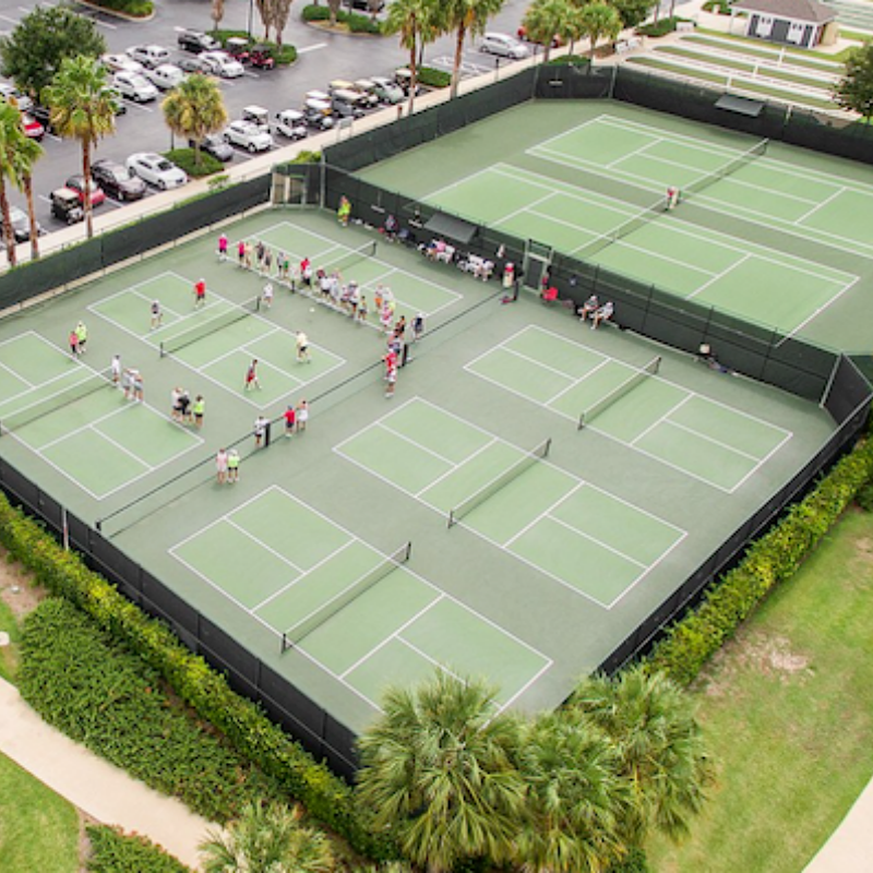 Aerial view of multiple pickleball courts with players engaged in matches and practice