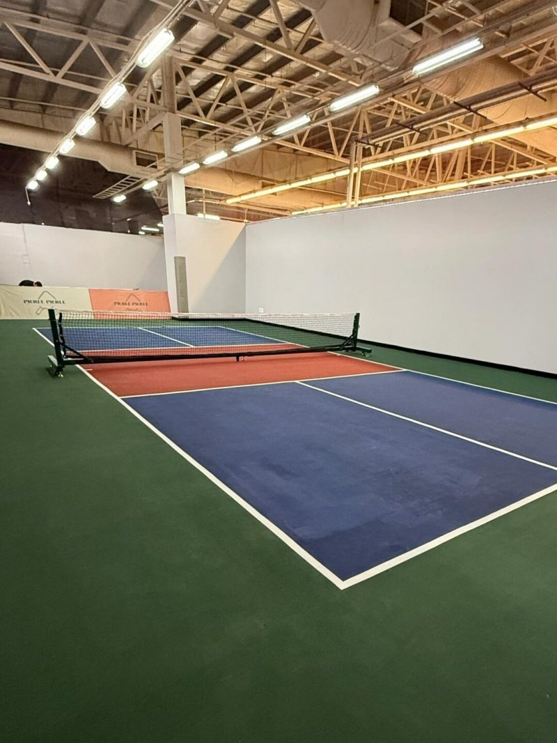Colorful indoor pickleball court Indoor pickleball court with blue, red, and green surface