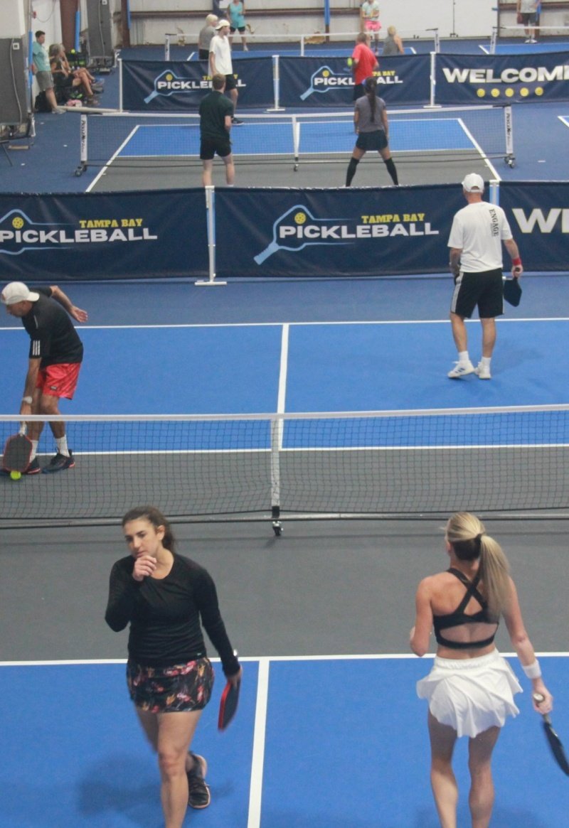 Indoor Pickleball Game Indoor pickleball courts with multiple players in action