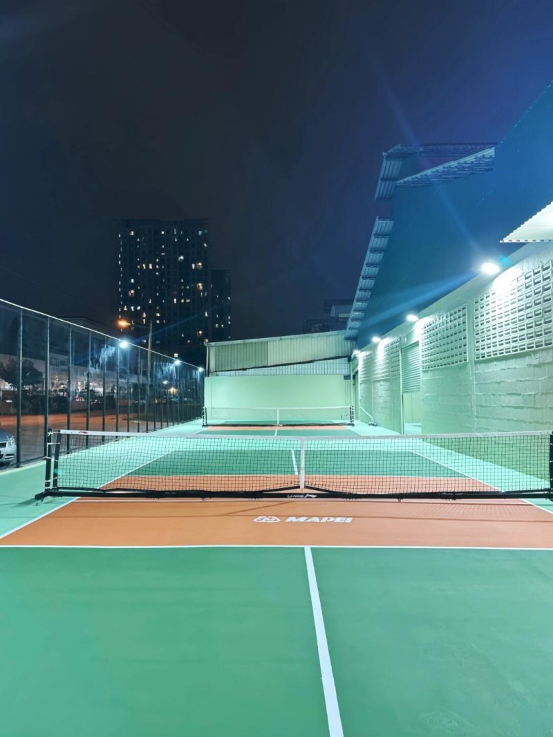 Nighttime pickleball courts Outdoor pickleball courts at night with city lights in the background