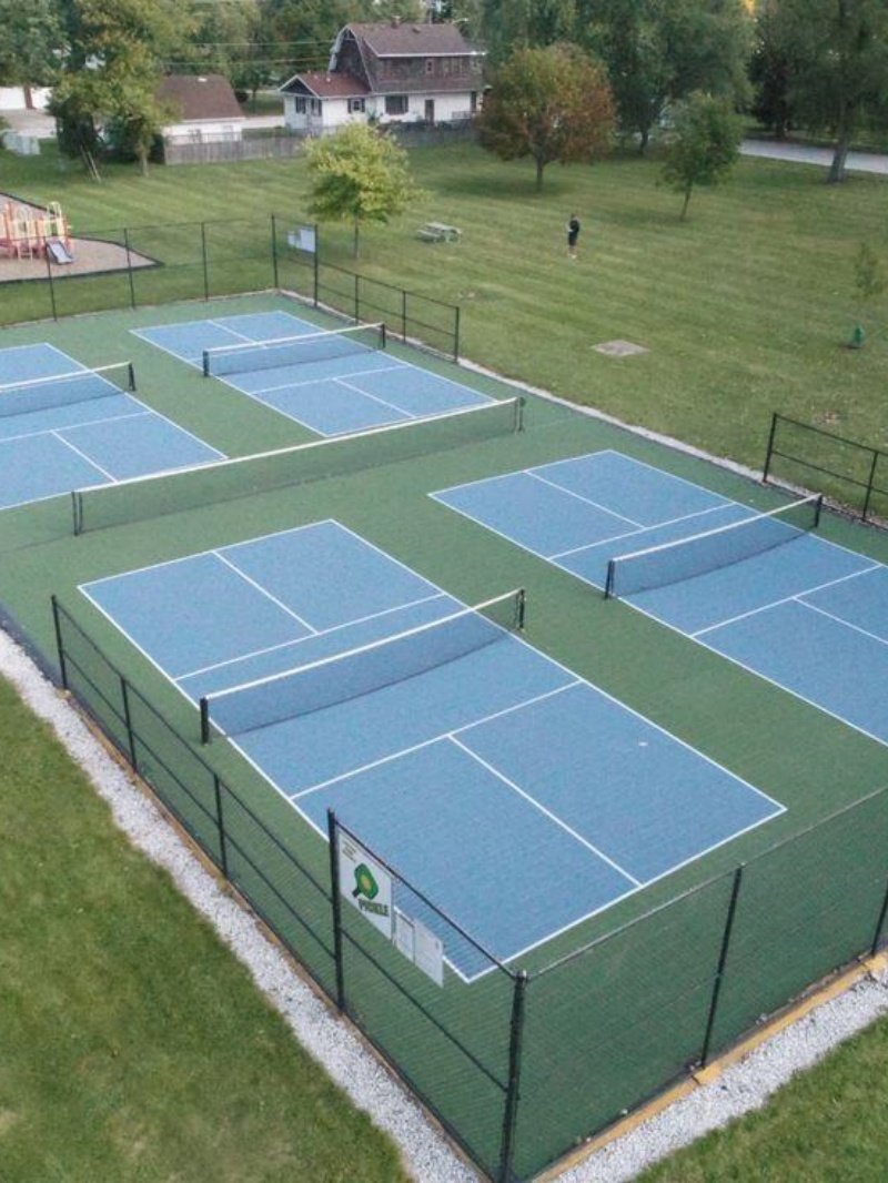Outdoor pickleball court setup Multiple outdoor pickleball courts in green park setting