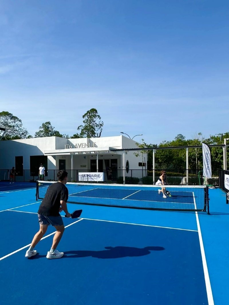Pickleball Game in Action Two players engaged in a pickleball match on a blue outdoor court