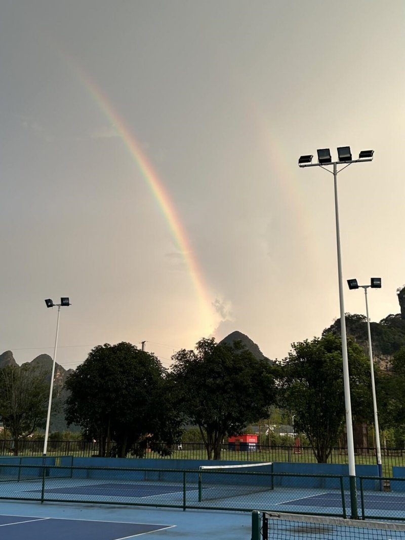 Pickleball courts with a rainbow view Outdoor pickleball courts with a double rainbow over mountains