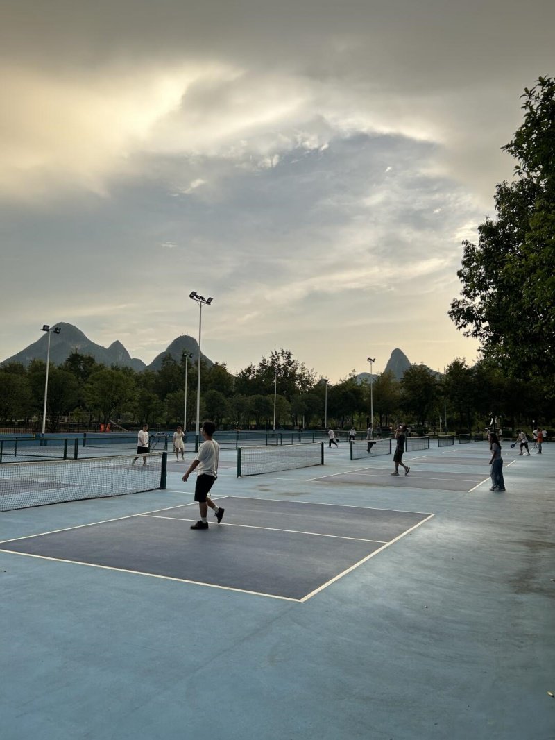 Scenic pickleball courts at dusk Players enjoying pickleball on outdoor courts with mountains in the background