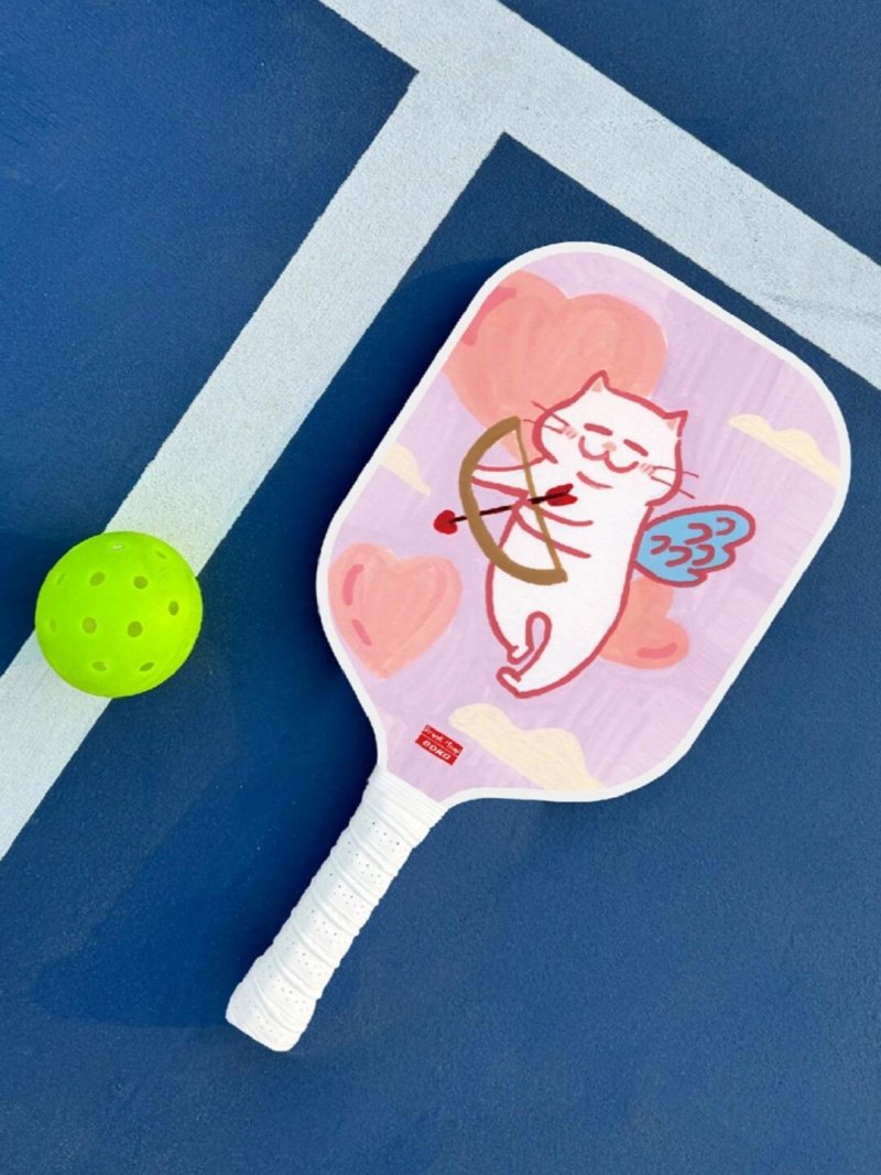 Cupid Cat Paddle Pink pickleball paddle with cupid cat design and green ball on blue court