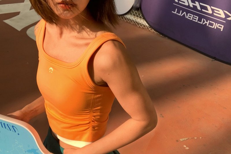 Close-up of woman holding pickleball paddle on court