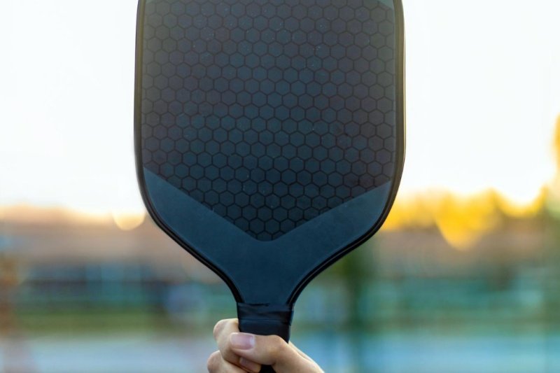 Pickleball paddle close-up Hand holding pickleball paddle with honeycomb design