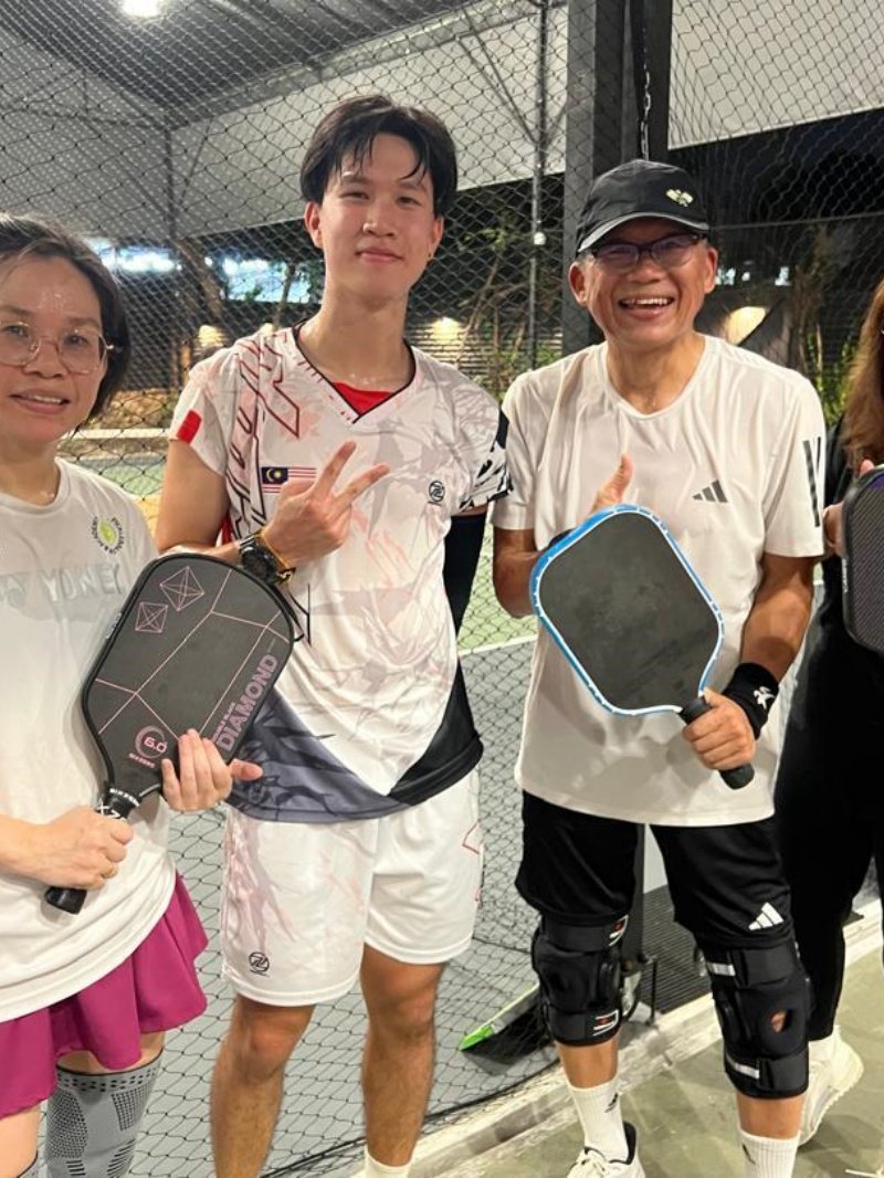 Post-Game Pickleball Group Three pickleball players smiling and holding paddles after a game
