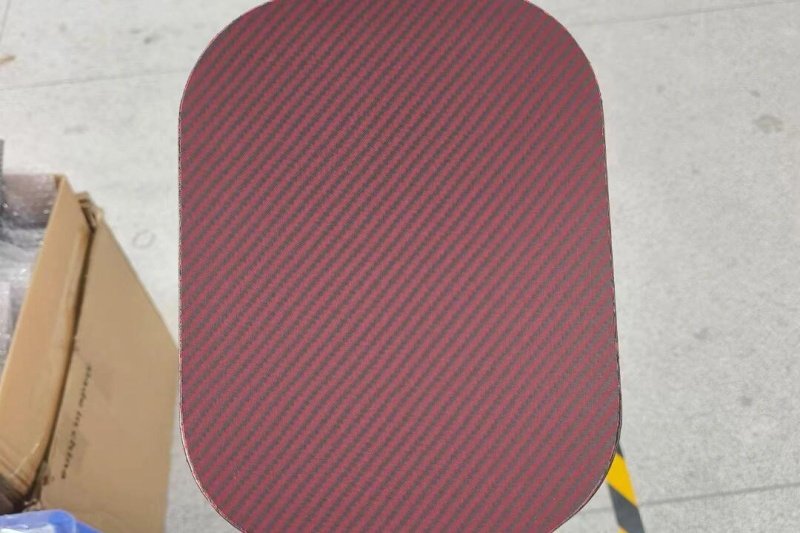 Red and black textured paddle surface Close-up of a red and black textured pickleball paddle surface