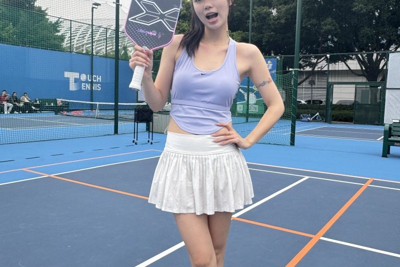 pickleball-paddle-court Woman in tennis skirt holding pickleball paddle on court