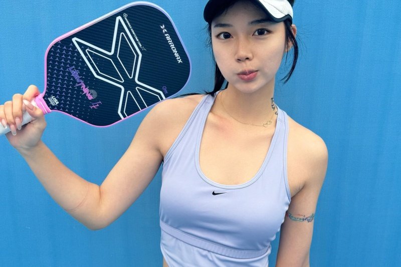 pickleball-paddle-model Woman with pickleball paddle, posing playfully in sportswear