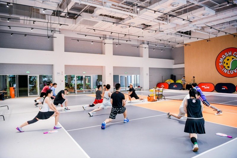 Group Warm-Up Stretching Pickleball players stretching before indoor session