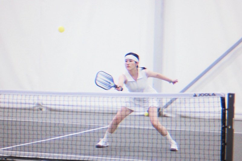 Pickleball Net Play Action Female pickleball player lunging at net for return shot