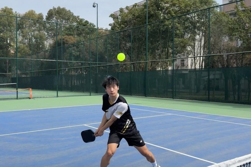 Returning Pickleball Shot Pickleball player focused on incoming shot at net